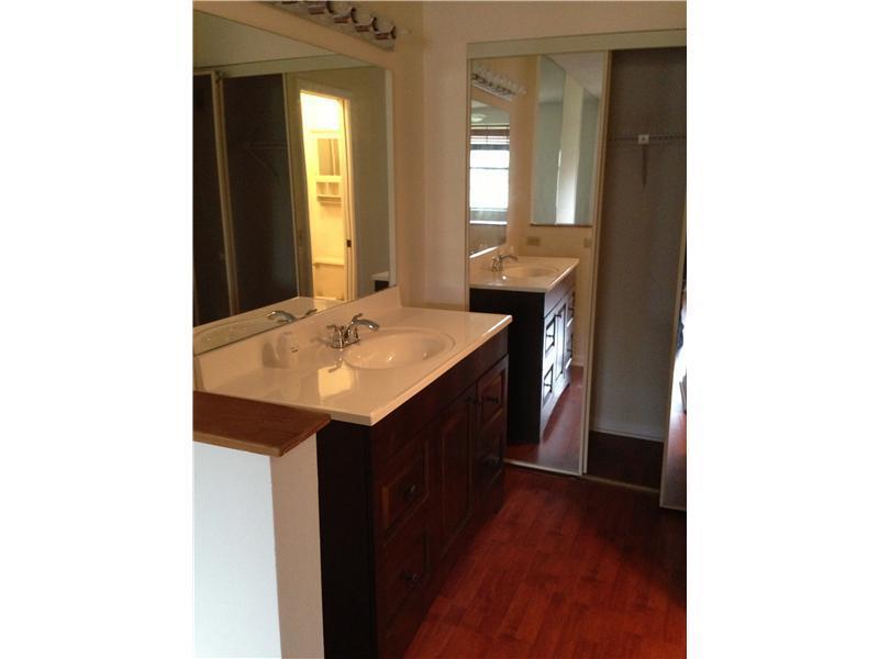 6542 Via Regina, Unit 11 Boca Raton, FL 33433 - Photo 3 of 11 a en suite bathroom with a sink and a mirror