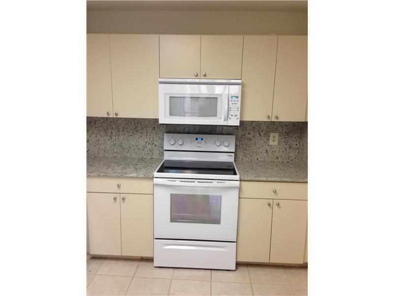 6542 Via Regina, Unit 11 Boca Raton, FL 33433 - Photo 5 of 11 a kitchen with a stove top oven and sink