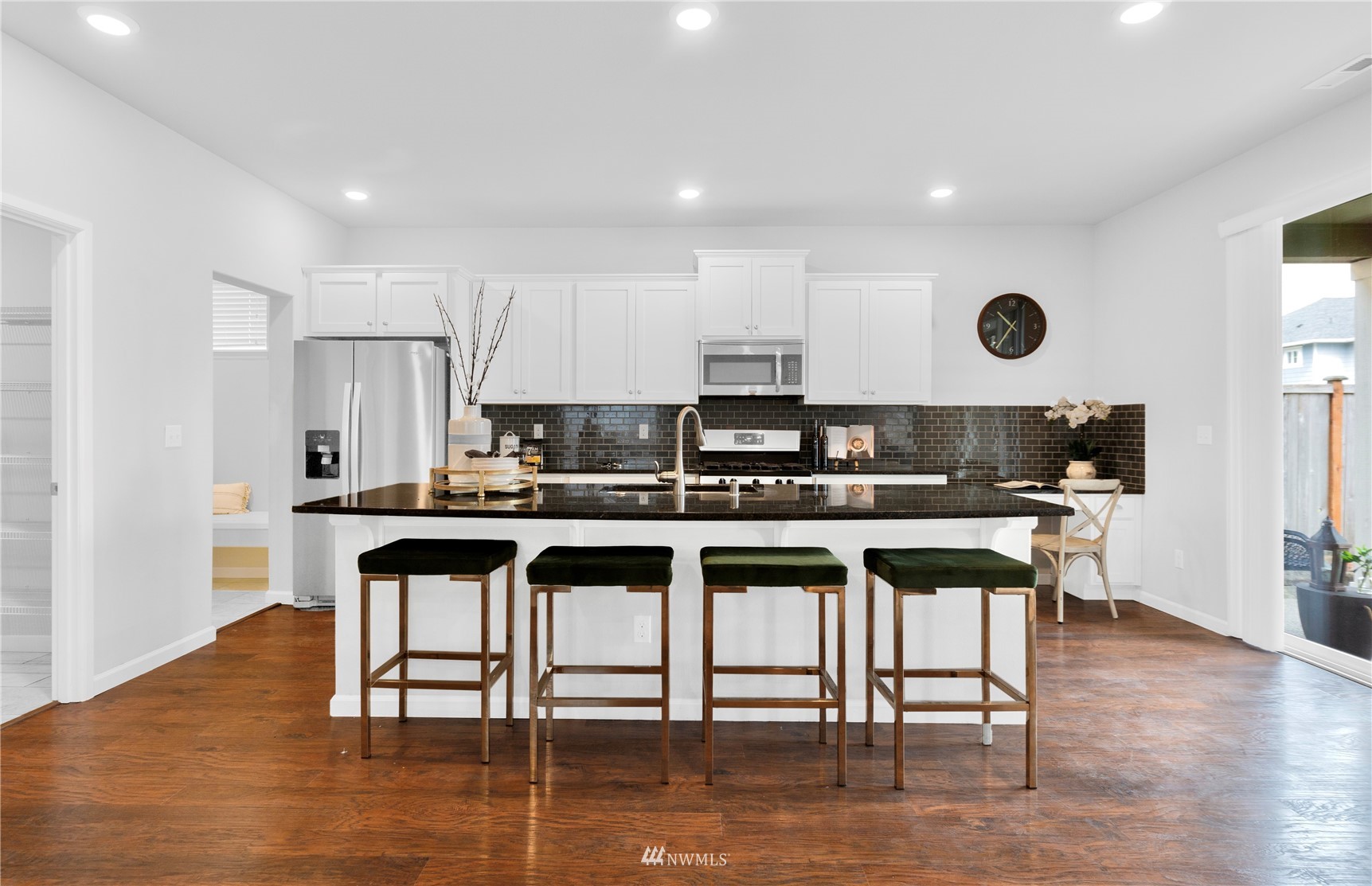 25 159th Place Southeast Bothell, WA 98012 - Photo 3 of 12 a kitchen with stainless steel appliances granite countertop a stove top oven a sink a dining table and chairs with wooden floor