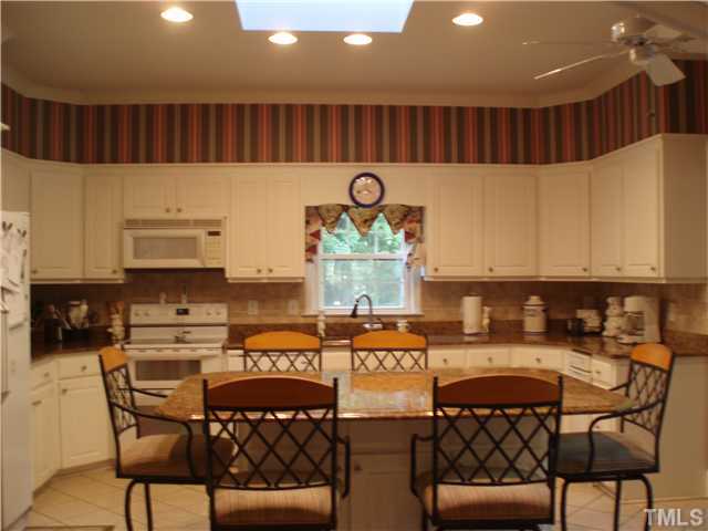 2565 Fairground Road Benson, NC 27504 - Photo 4 of 22 a kitchen with stainless steel appliances granite countertop a table chairs and a refrigerator