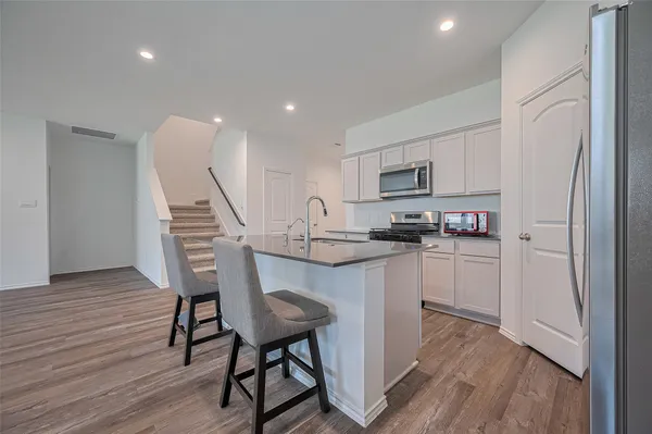 a view of a hallway with wooden floor and entryway