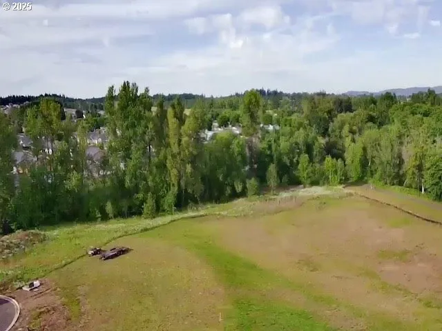 a view of a field with an trees in back