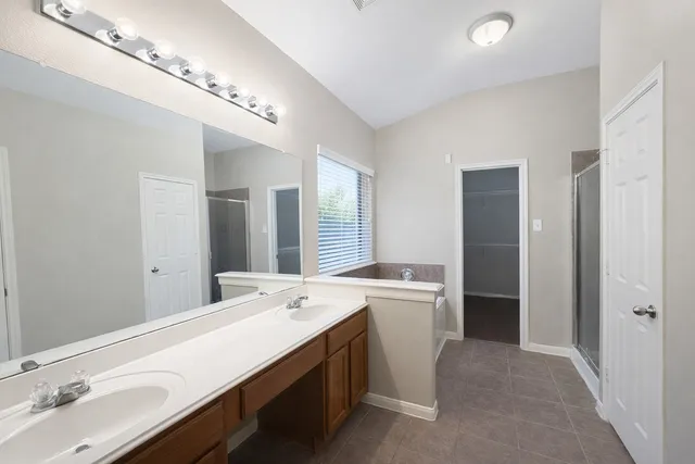 a room with a sink a mirror and a washer dryer