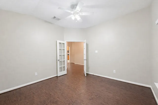 an empty room with a ceiling fan and a window