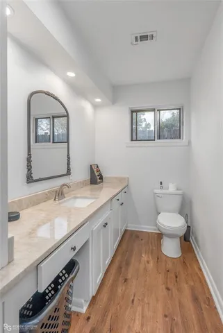 a bathroom with a granite countertop toilet sink and mirror