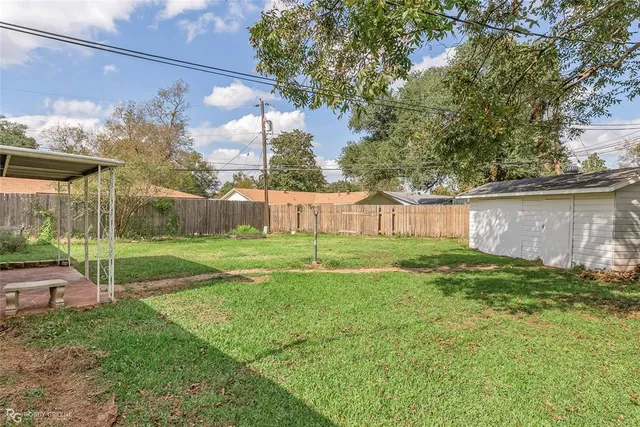 a view of a house with a garden and a tree