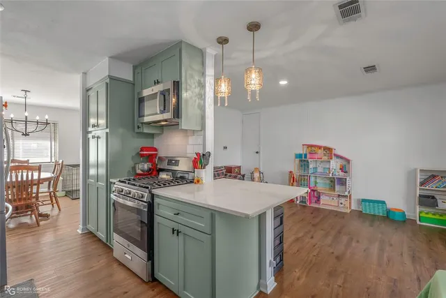 a kitchen that has a lot of cabinets a sink and a wooden floor