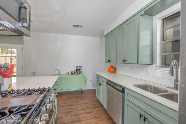 a kitchen with stainless steel appliances granite countertop a sink and a stove