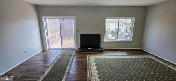 a view of a livingroom with wooden floor and a rug