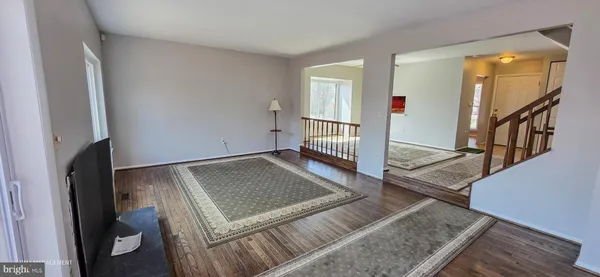 a living room with wooden floor and a rug