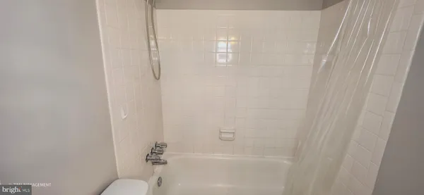 a bathroom with a granite countertop toilet and a shower