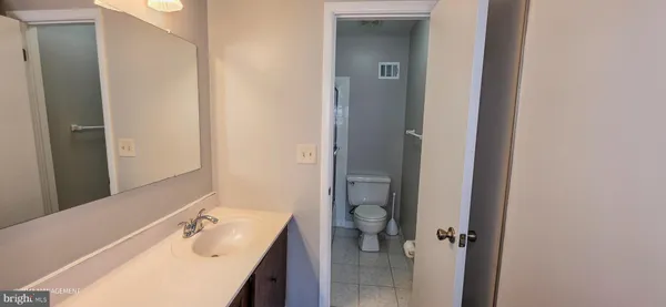 a bathroom with a tub sink vanity granite and shower