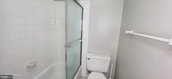 a white toilet sitting next to a shower