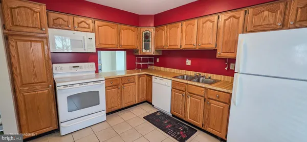 a kitchen with stainless steel appliances granite countertop a refrigerator sink stove and cabinets