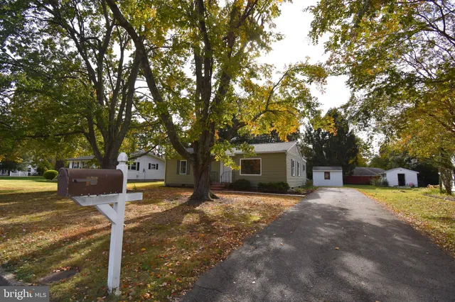 a front view of a house with yard and trees