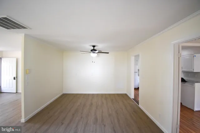 a view of a room with wooden floor and a ceiling fan