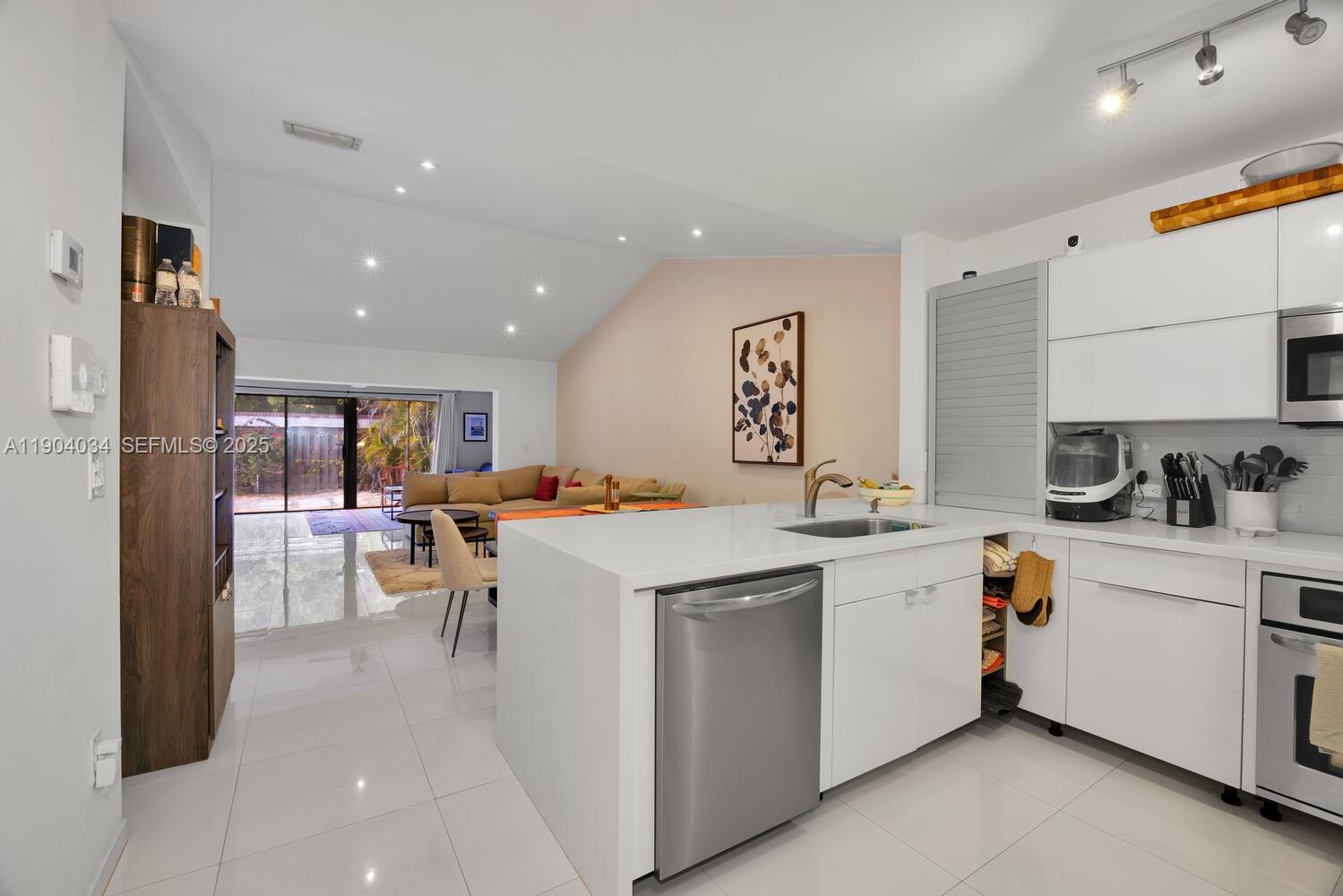 a kitchen with a sink window and stainless steel appliances