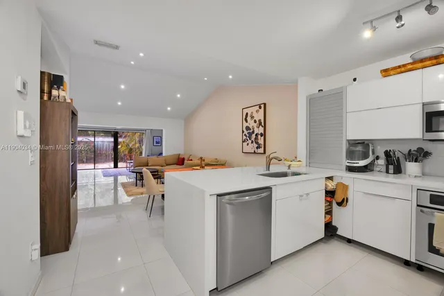 a kitchen with a sink window and stainless steel appliances