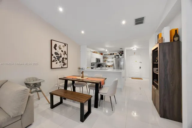 a living room with furniture and a refrigerator