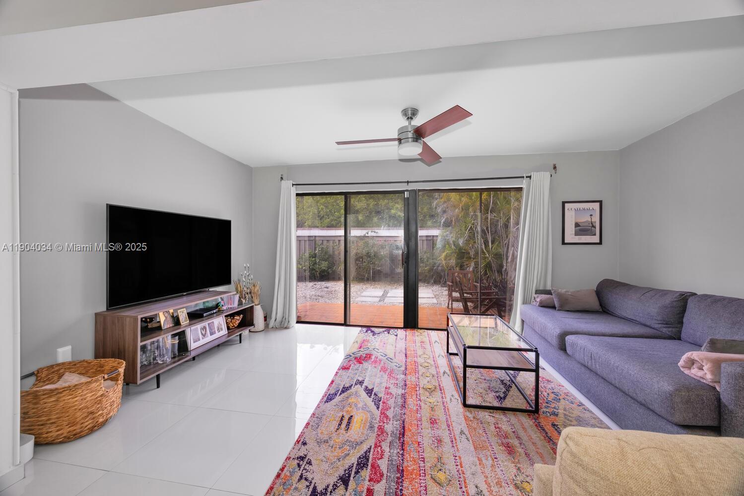 8596 Southwest 115th Place Miami, FL 33173 - Photo 17 of 39 a living room with furniture and a flat screen tv