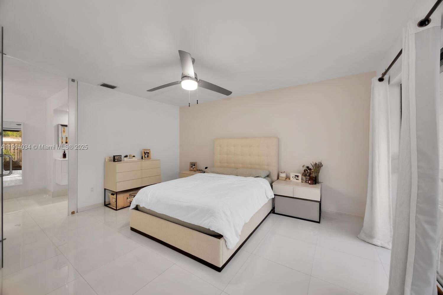 8596 Southwest 115th Place Miami, FL 33173 - Photo 20 of 39 a bedroom with a bed and a chandelier