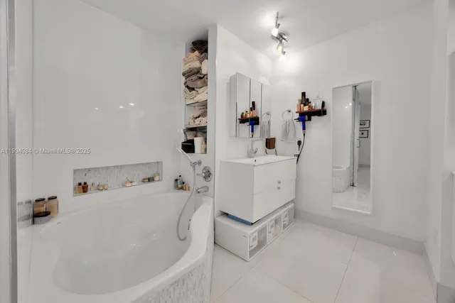 a white bath tub sitting next to a white sink