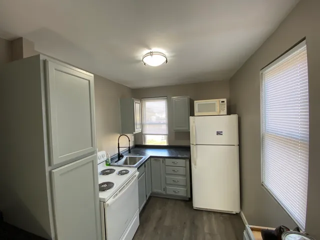 a kitchen with a refrigerator a stove a sink and a window