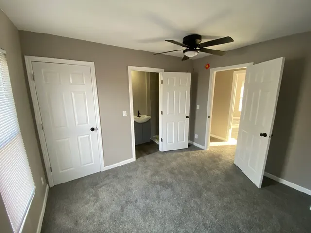 a view of empty room with wooden floor and ceiling fan