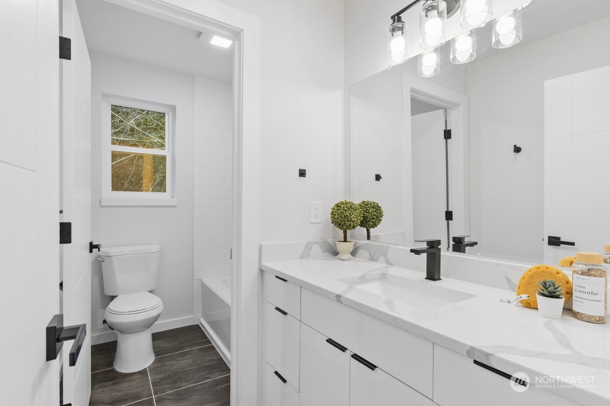 7511 Dumar Way Southwest Seattle, WA 98106 - Photo 22 of 35 a bathroom with a sink a toilet and a mirror