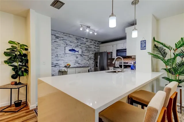 a kitchen with a sink cabinets and wooden floor