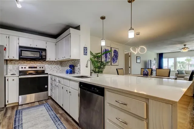 a kitchen with stainless steel appliances a stove a refrigerator and a cabinets