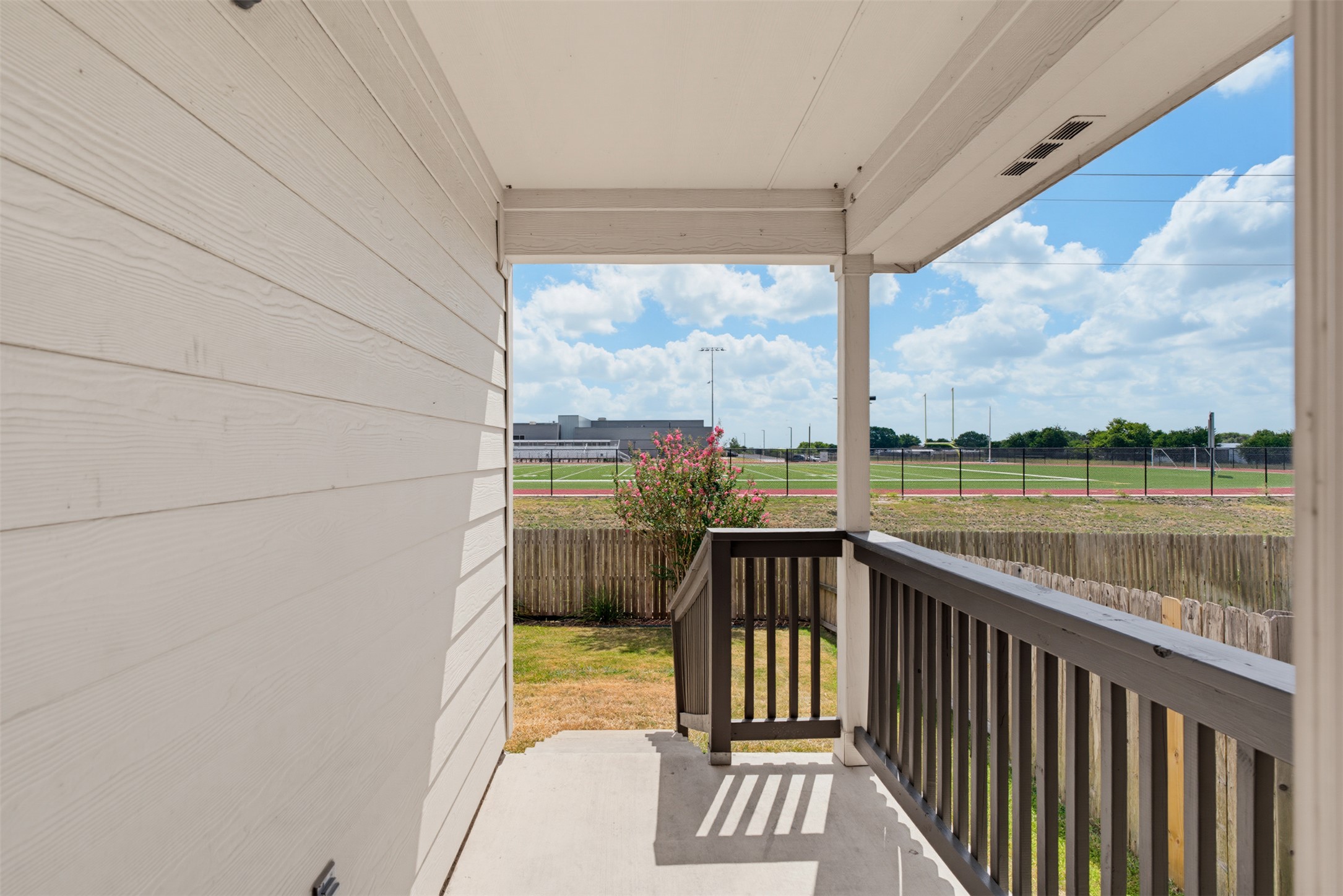 6033 Roma Street Round Rock, TX 78665 - Photo 26 of 28 Concrete steps descend from a covered porch toward a fenced lawn with open views.