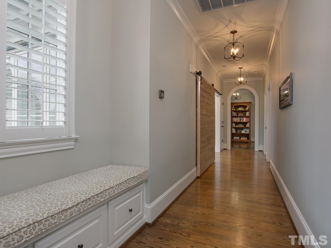 507 Guilford Circle Raleigh, NC 27608 - Photo 16 of 26 a hallway with wooden floor closet and chandelier
