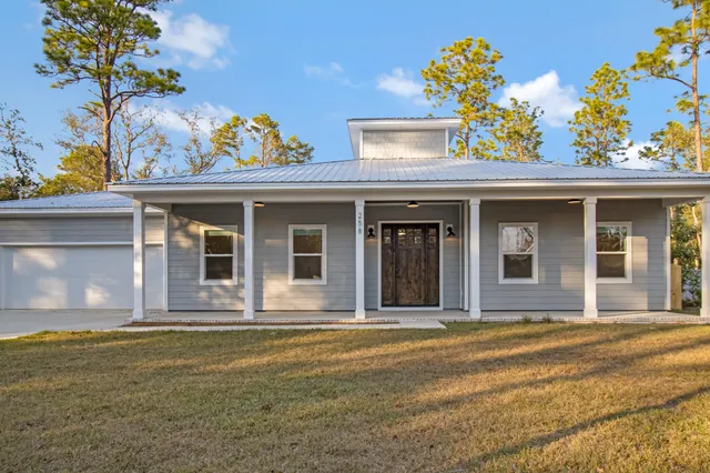 a view of a yard in front of a house with large trees