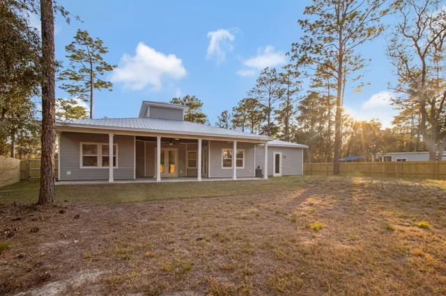 a living room with furniture a ceiling fan and a flat screen tv