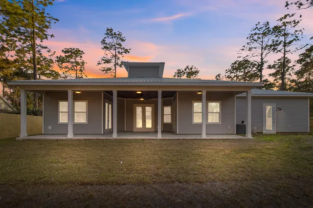 a view of house with a yard and potted plants