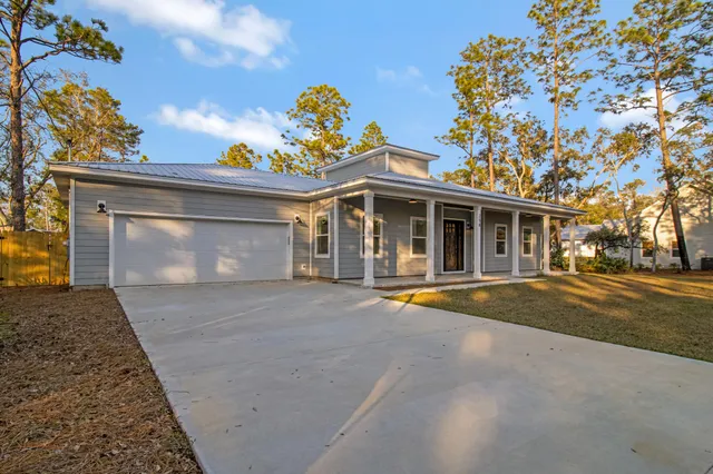 a front view of a house with a yard and trees