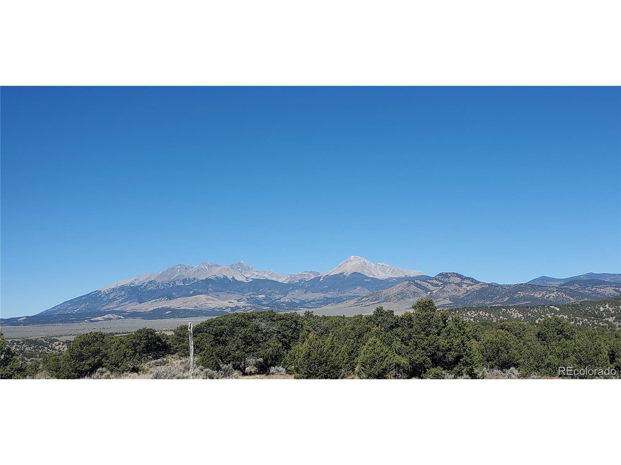 a view of mountain with sunset in background