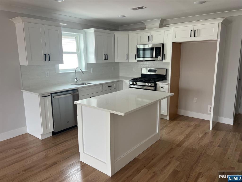 1060 Magnolia Avenue Elizabeth, NJ 07201 - Photo 11 of 22 a kitchen with wooden cabinets and stainless steel appliances