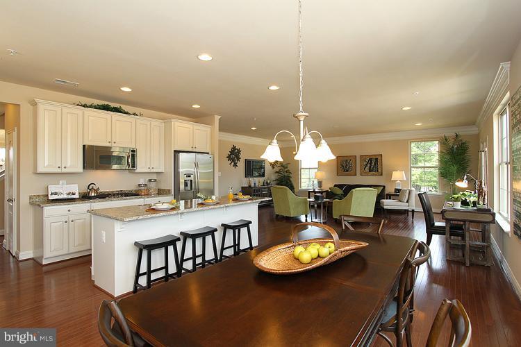 3041 Bel Pre Road Silver Spring, MD 20906 - Photo 11 of 28 a large kitchen with a table chairs stove and wooden floor
