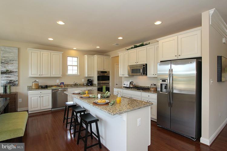 3041 Bel Pre Road Silver Spring, MD 20906 - Photo 13 of 28 a kitchen with a refrigerator a stove a sink a dining table and chairs