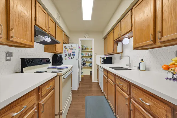 a kitchen with stainless steel appliances granite countertop a sink and dishwasher a stove top oven with wooden floor
