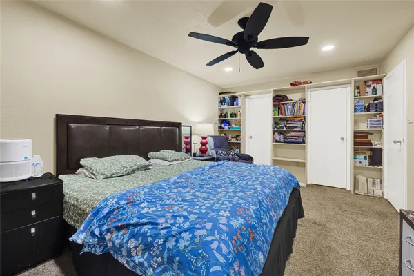 a bedroom with a large bed and a chandelier