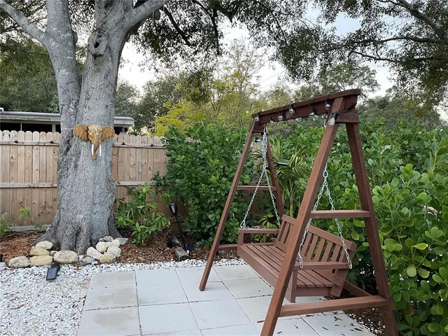 a view of backyard with plants and large tree