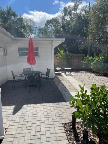 a view of a patio with table and chairs and potted plants