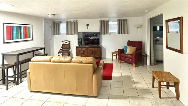 a living room with furniture a flat screen tv and kitchen view