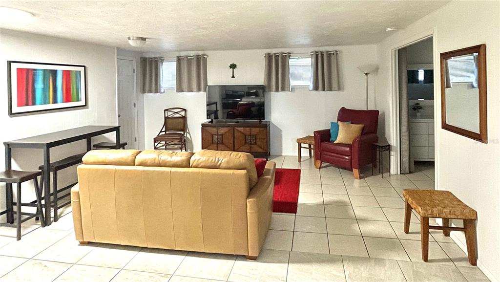 828 South Tuttle Avenue, Unit B Sarasota, FL 34237 - Photo 3 of 63 a living room with furniture a flat screen tv and kitchen view