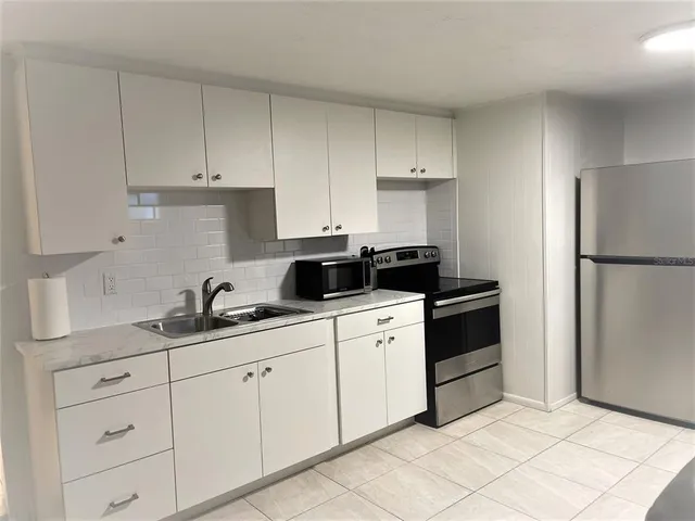 a kitchen with white cabinets and white appliances