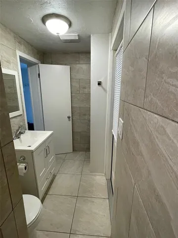 a bathroom with a granite countertop sink a toilet and mirror