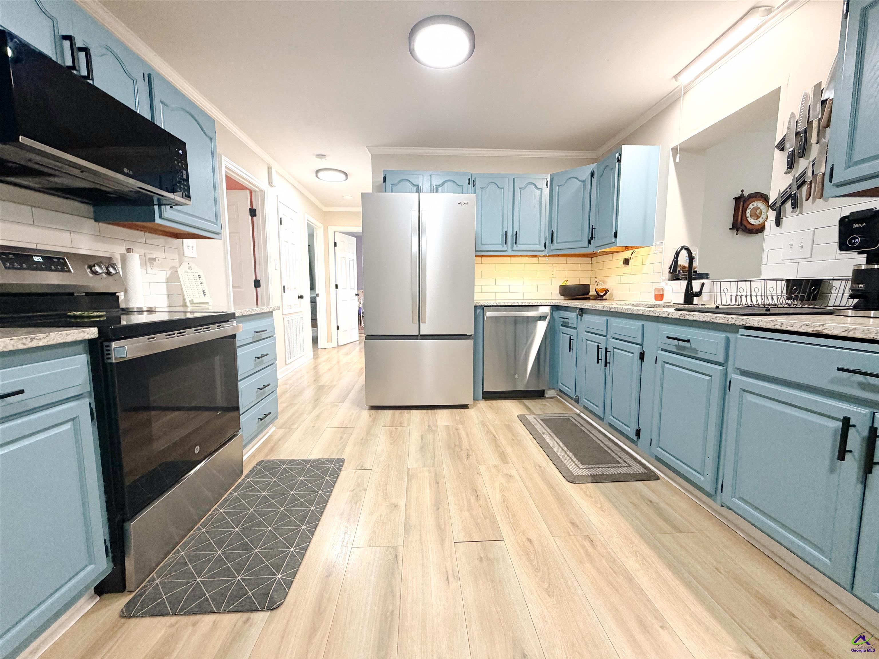 108 Weaver Road Warner Robins, GA 31093 - Photo 6 of 26 a kitchen with stainless steel appliances granite countertop a refrigerator a stove top oven a sink dishwasher and white cabinets with wooden floor